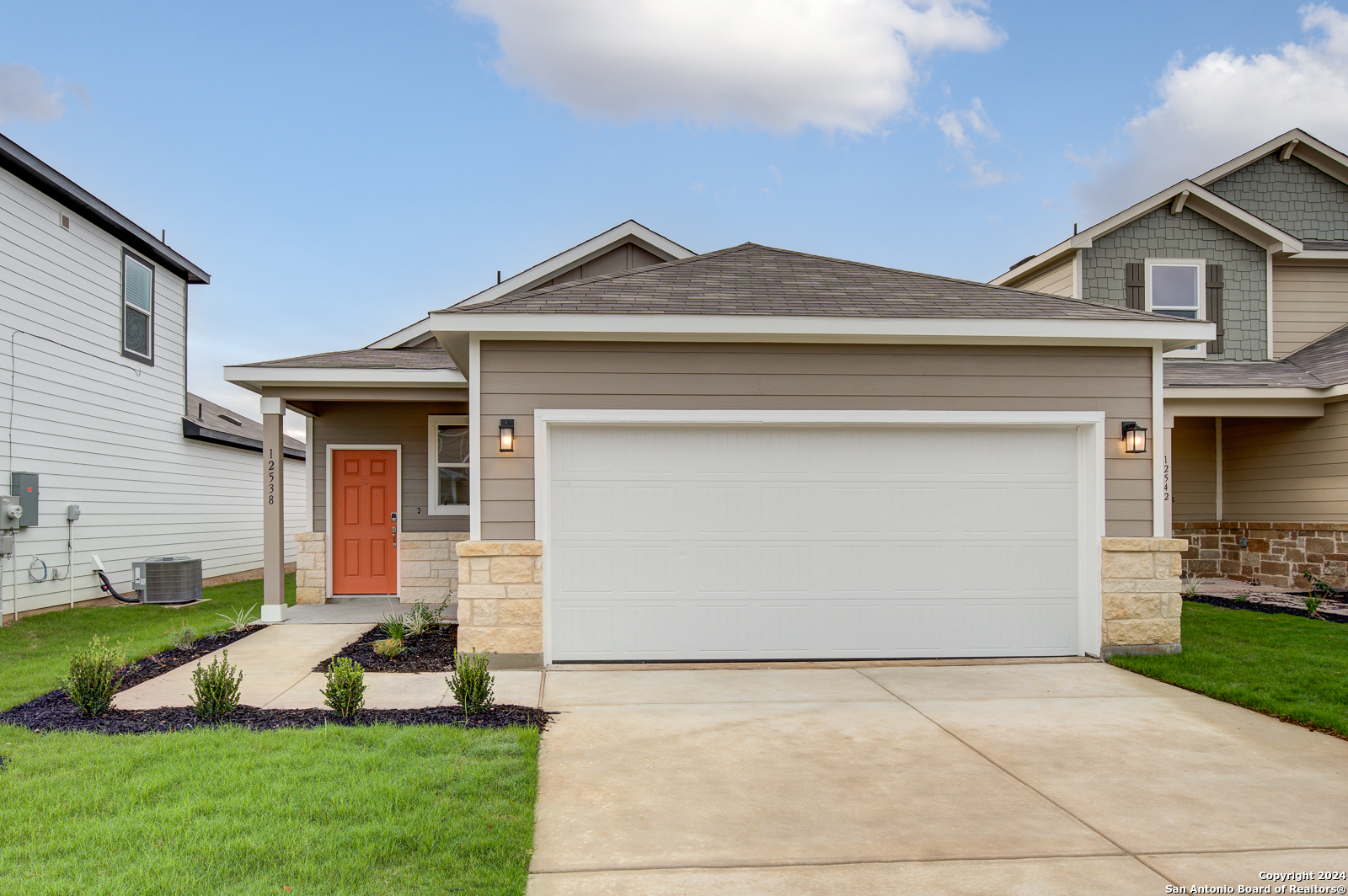 a front view of a house with a yard and garage