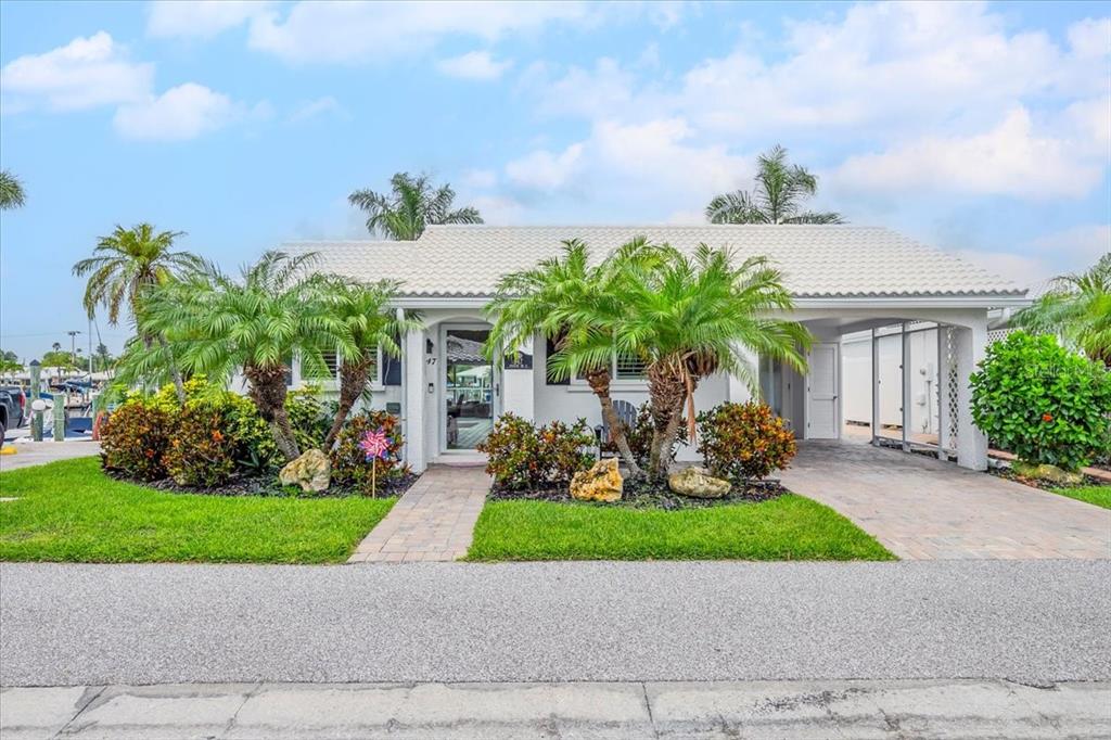 a front view of a house with a yard and potted plants