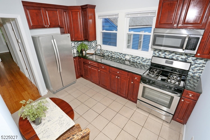 a kitchen with stainless steel appliances granite countertop a refrigerator a stove and a sink