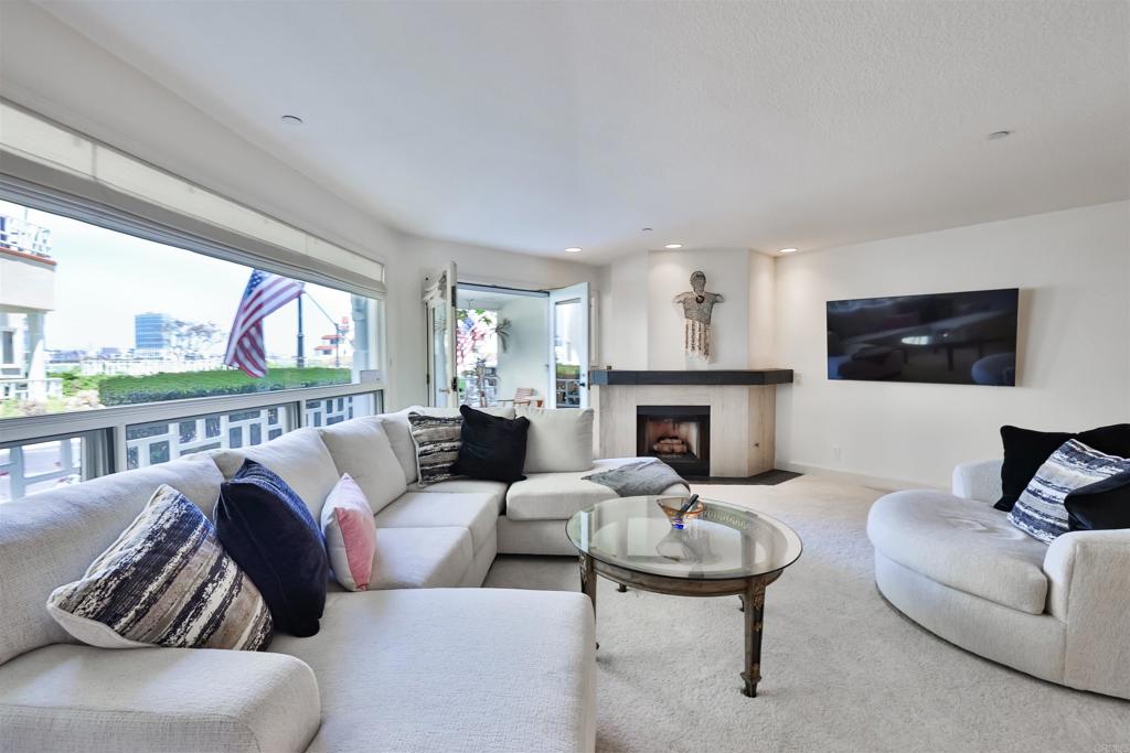 a living room with furniture fireplace and a large window