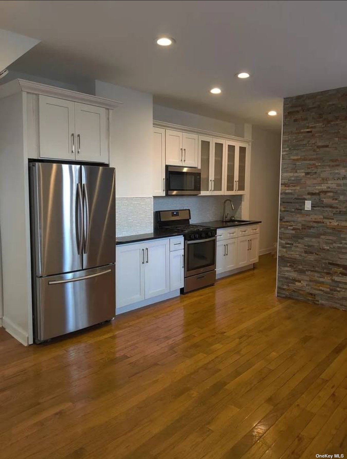 a kitchen with stainless steel appliances granite countertop a refrigerator and a stove top oven