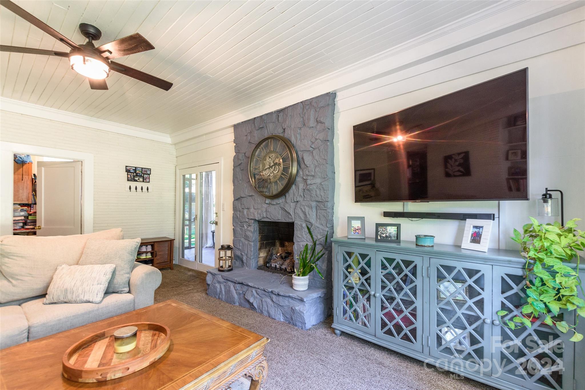 a living room with furniture a clock and a flat screen tv