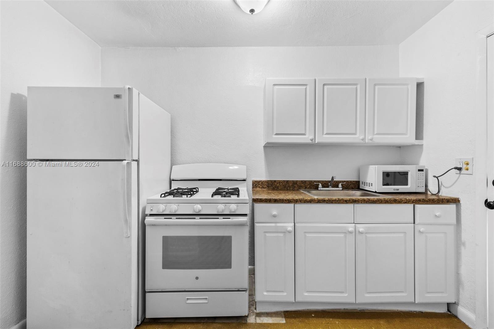 a kitchen with white cabinets and white appliances