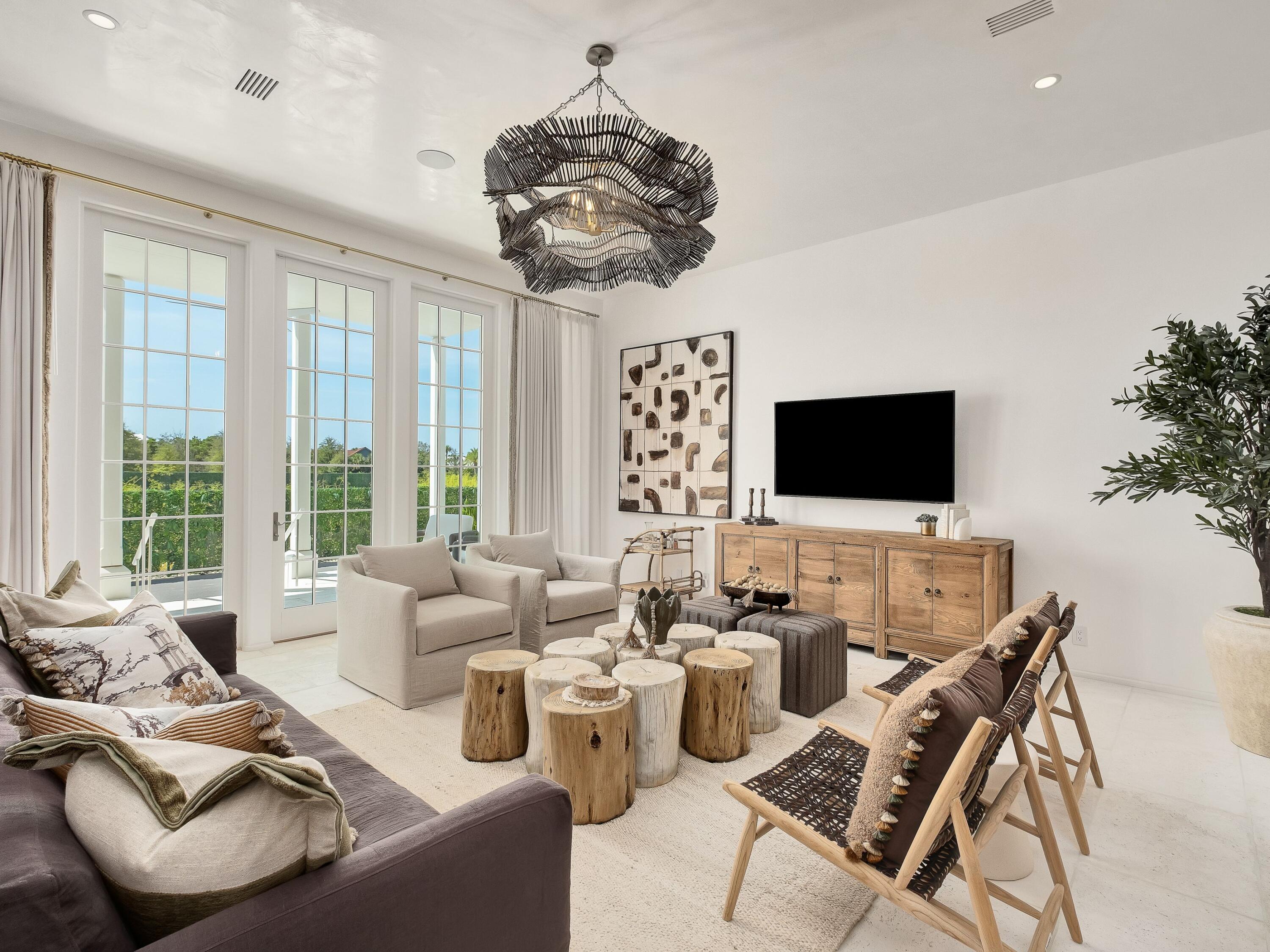 a living room with furniture a flat screen tv and a chandelier