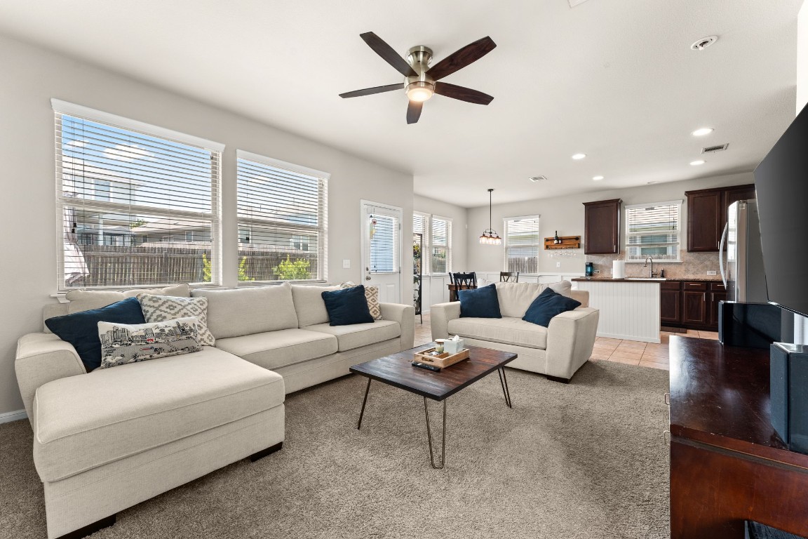 a living room with furniture kitchen view and a large window