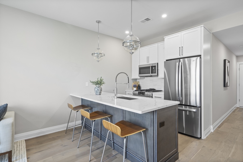 a kitchen with granite countertop a sink stove and refrigerator