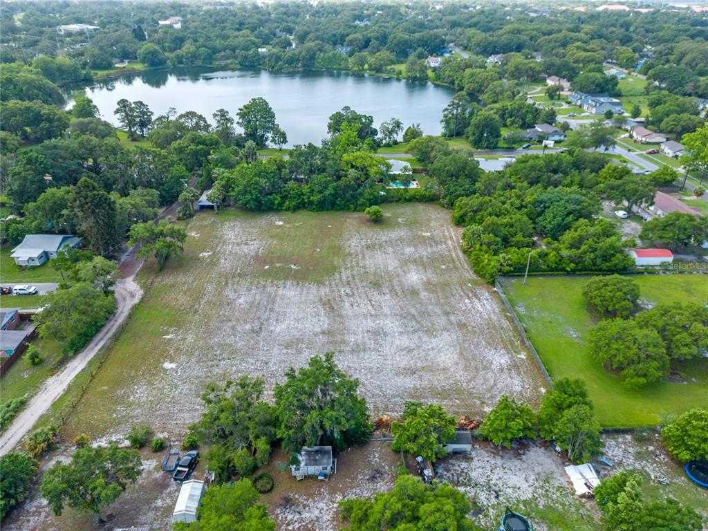 an aerial view of a house with a yard and lake view