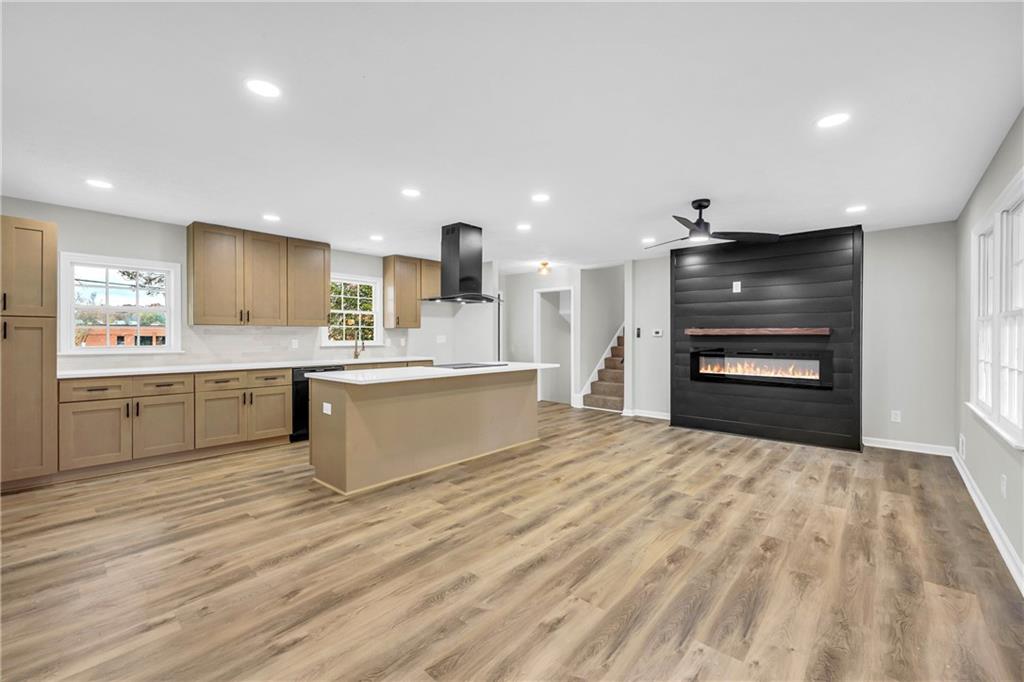 a large white kitchen with kitchen island a sink stainless steel appliances and cabinets