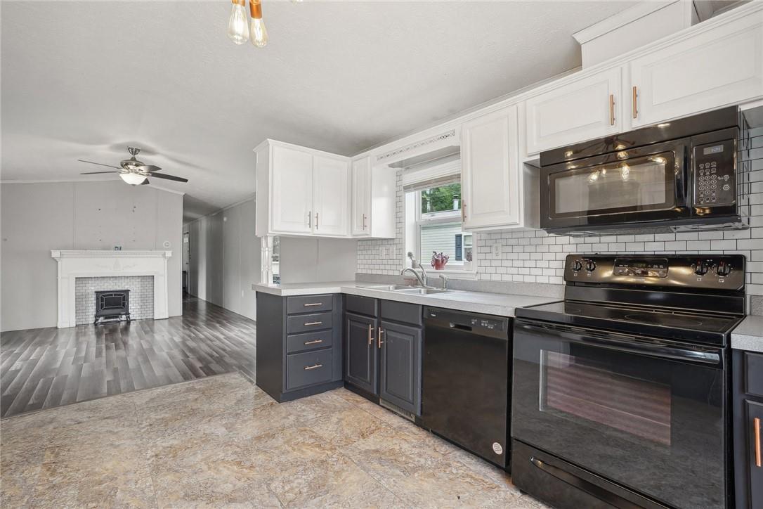 Kitchen with white cabinetry, ceiling fan, light hardwood / wood-style floors, black appliances, and decorative backsplash