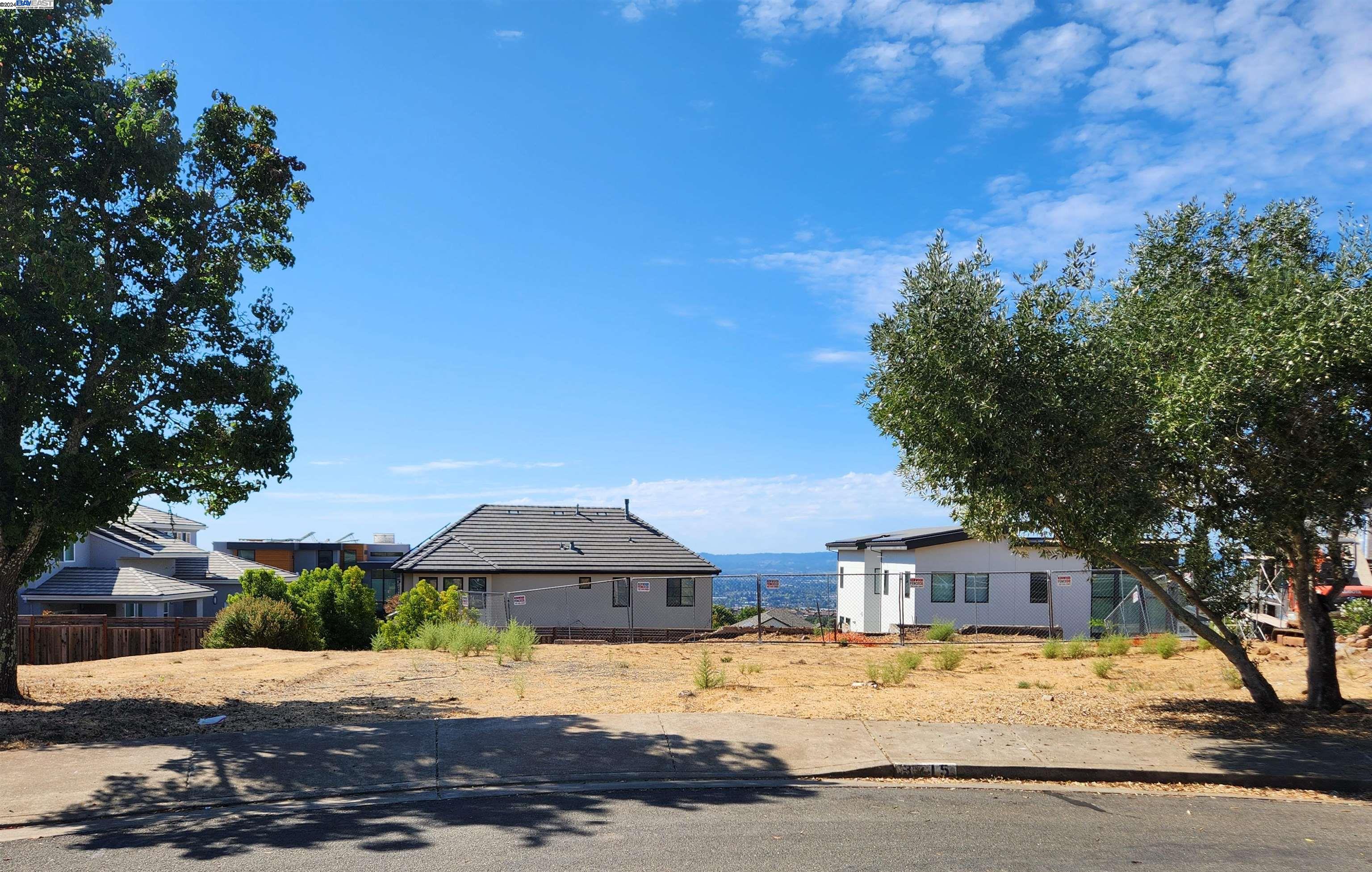 a front view of a house with a yard covered with trees