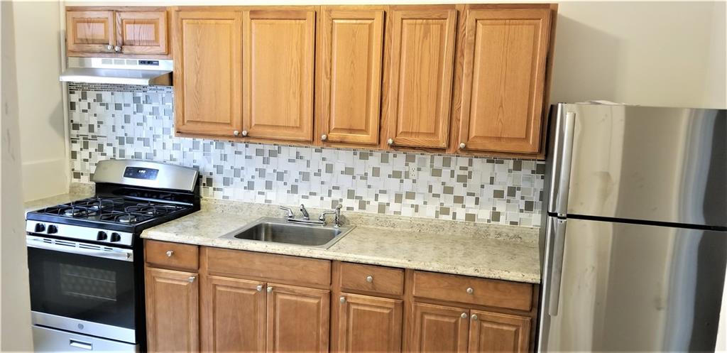 a kitchen with granite countertop a sink stove and refrigerator