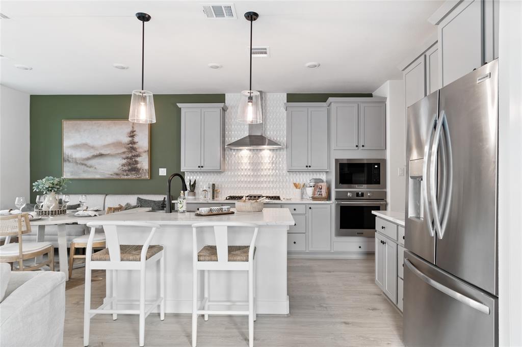 a kitchen with stainless steel appliances granite countertop a refrigerator a stove and white cabinets