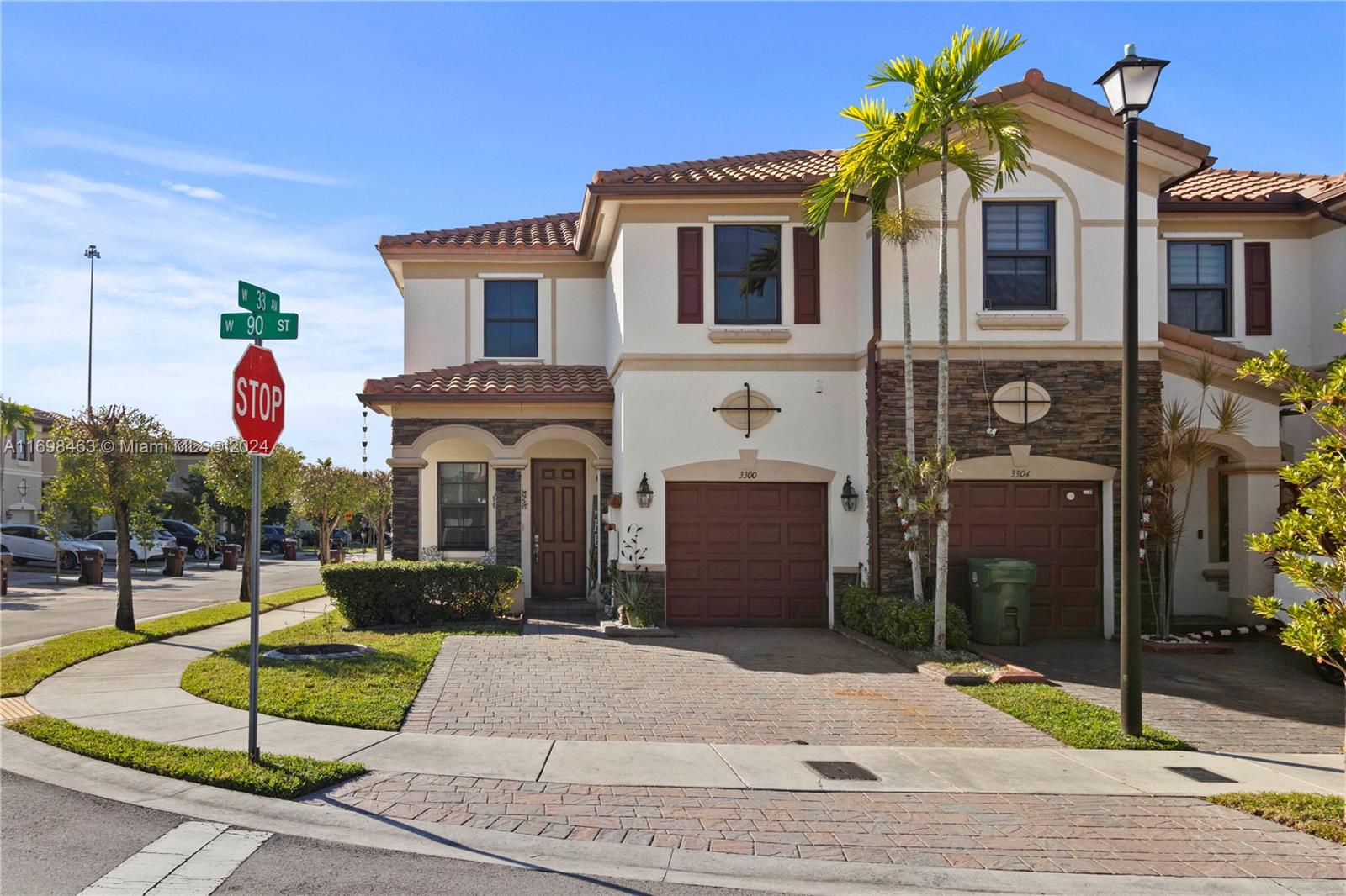 a front view of a house with entertaining space and palm trees