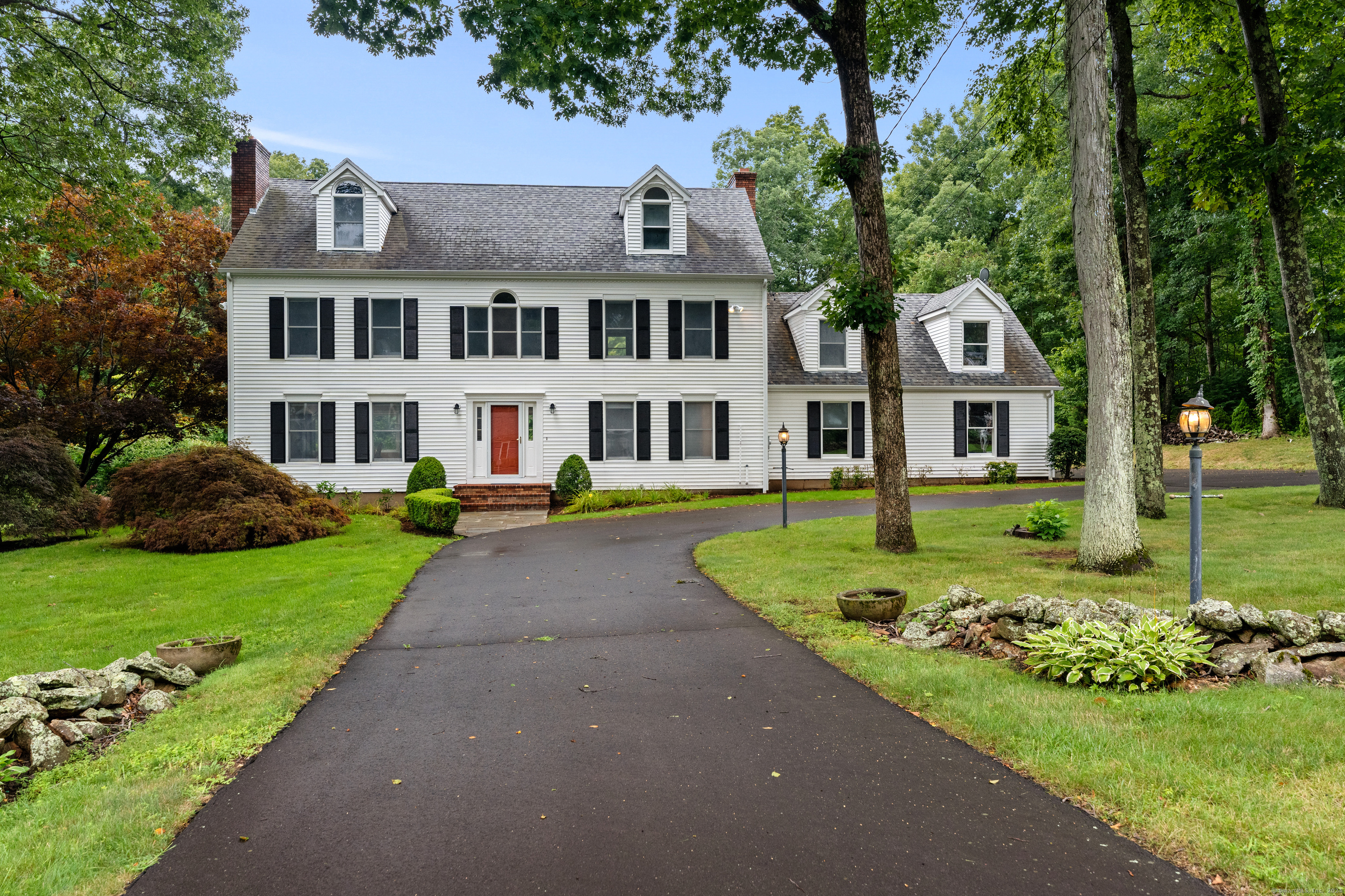 a front view of a residential houses with yard and green space