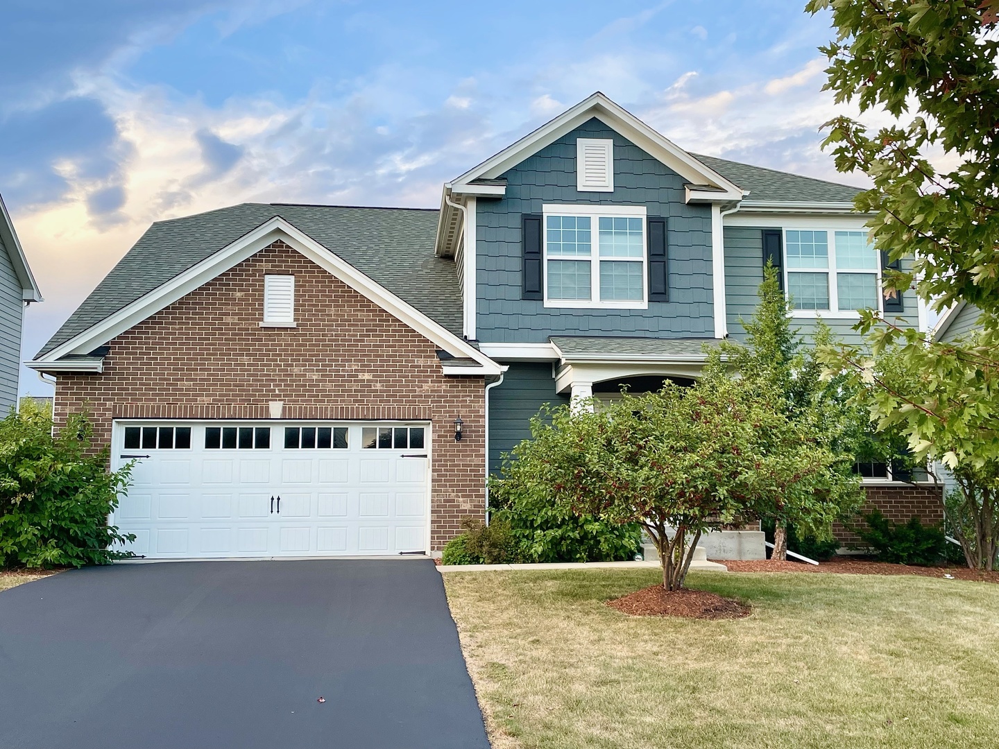 a front view of a house with a yard and garage