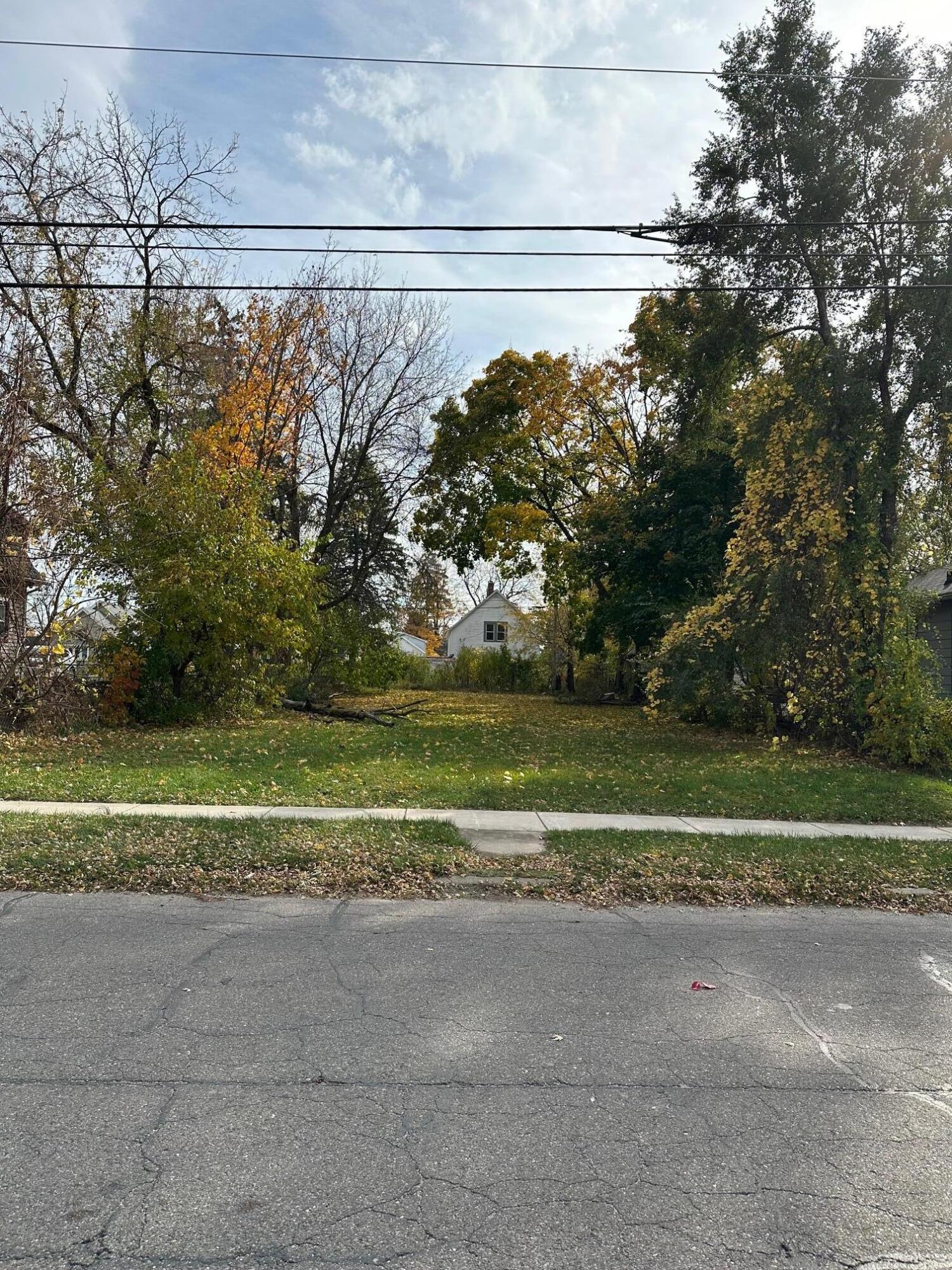 a view of a house with a big yard and large trees