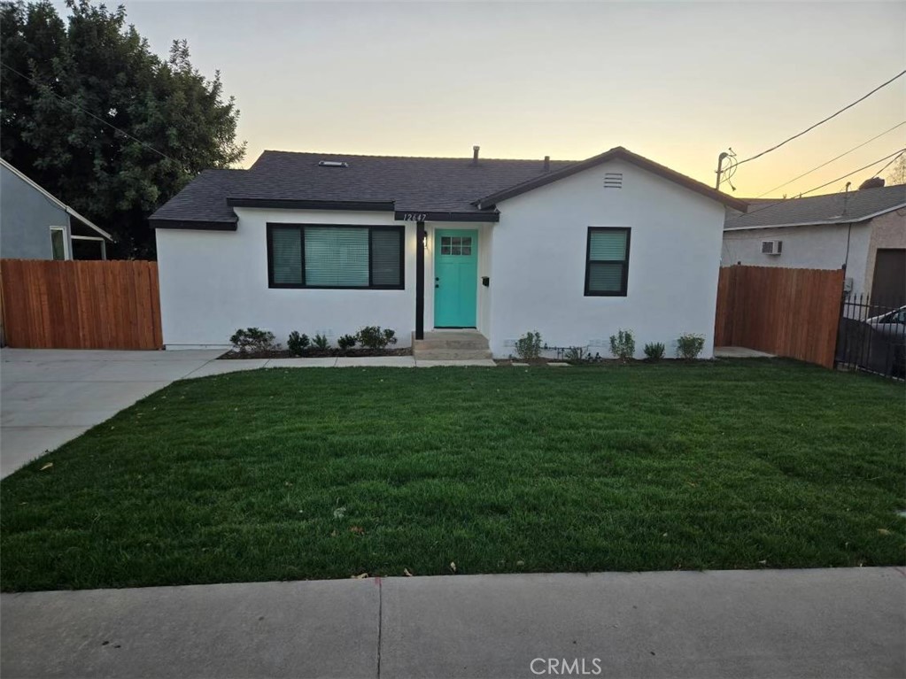 a front view of a house with a garden and yard