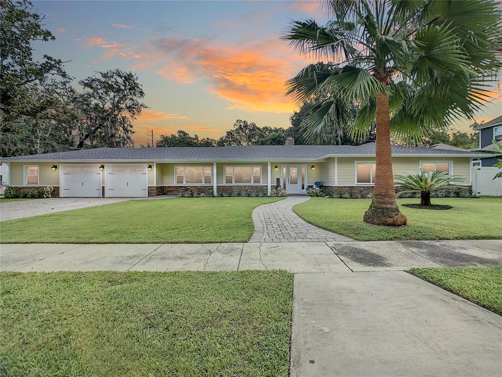 a view of house with a garden and palm trees