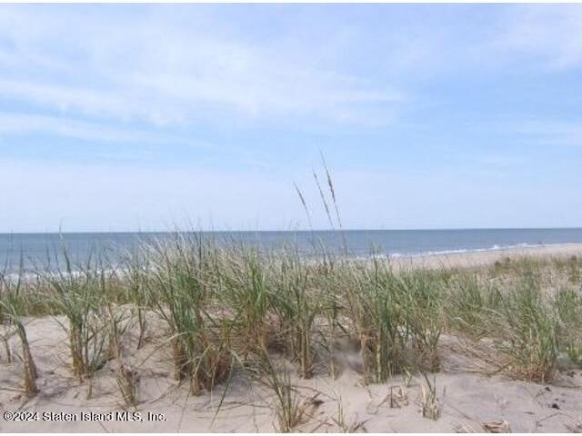 a view of a field with an ocean in the background