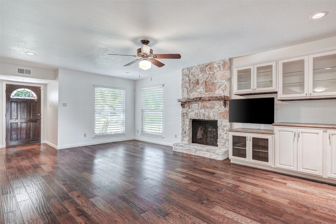 a view of a livingroom with a fireplace cabinet and windows