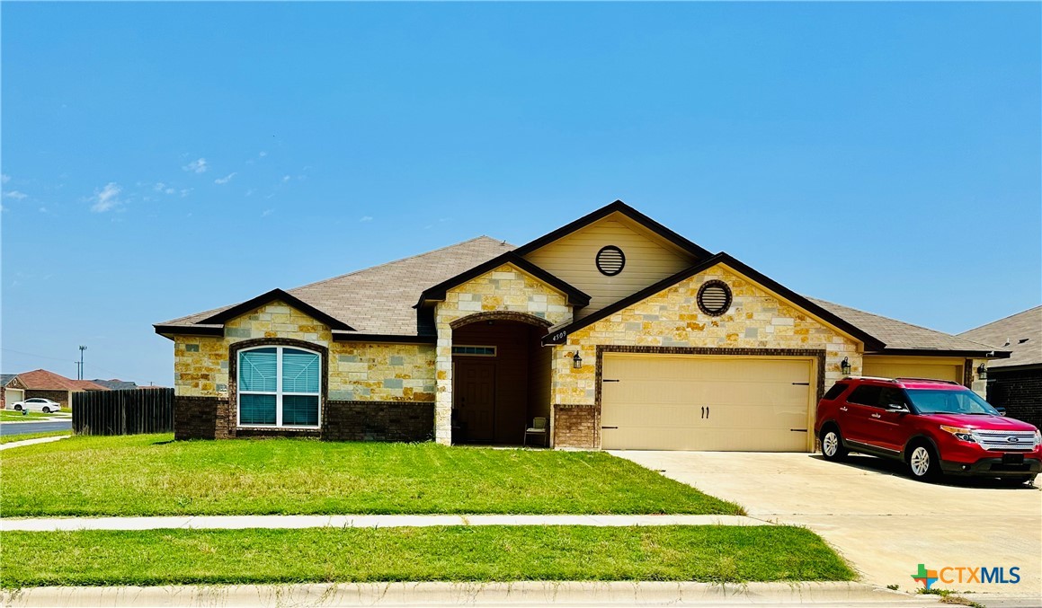 a front view of a house with a yard and garage