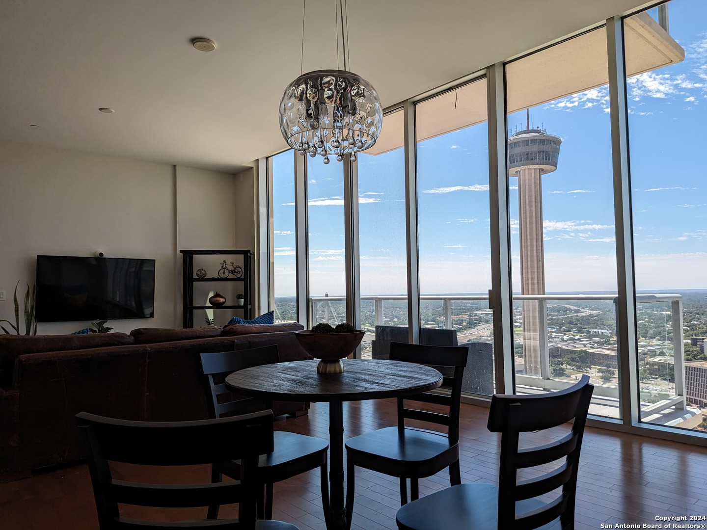 a dining room with furniture a chandelier and wooden floor