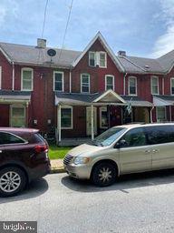 a car parked in front of a brick house