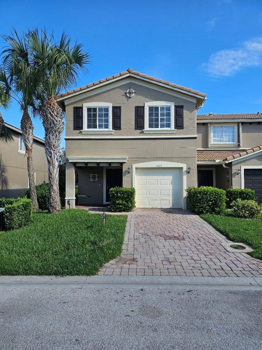 a front view of a house with a yard and garage