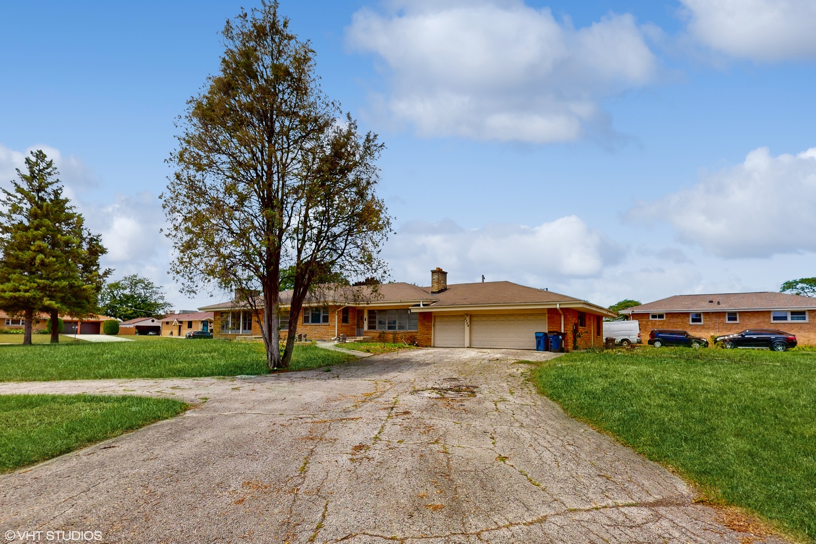 a view of a big house with a big yard and large trees