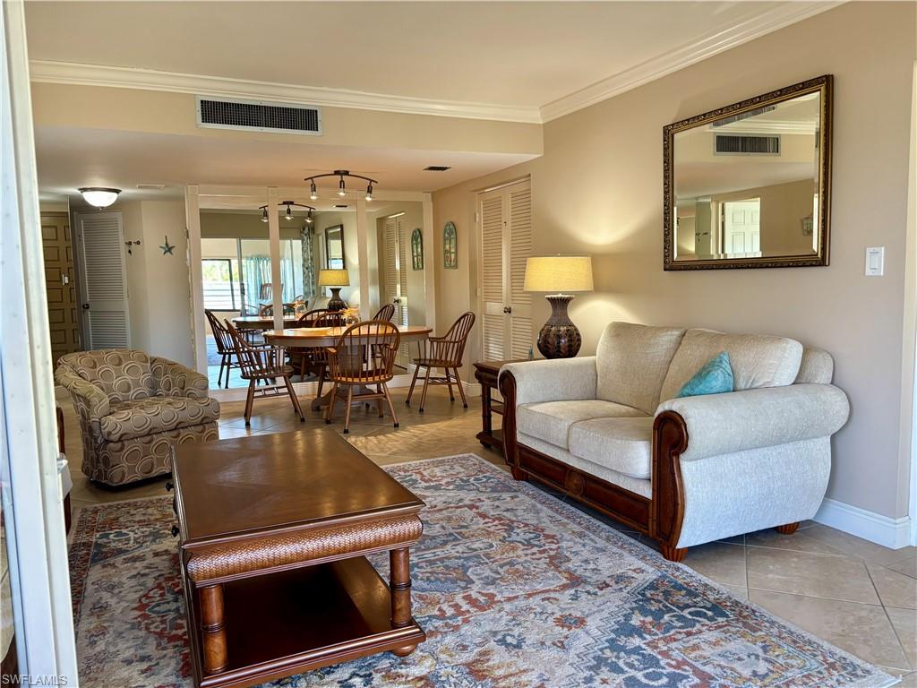 Living room featuring tile patterned floors and ornamental molding