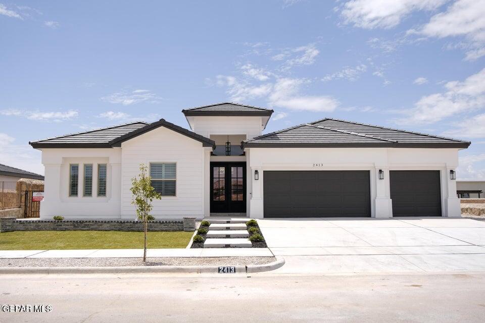 a front view of a house with a yard and garage