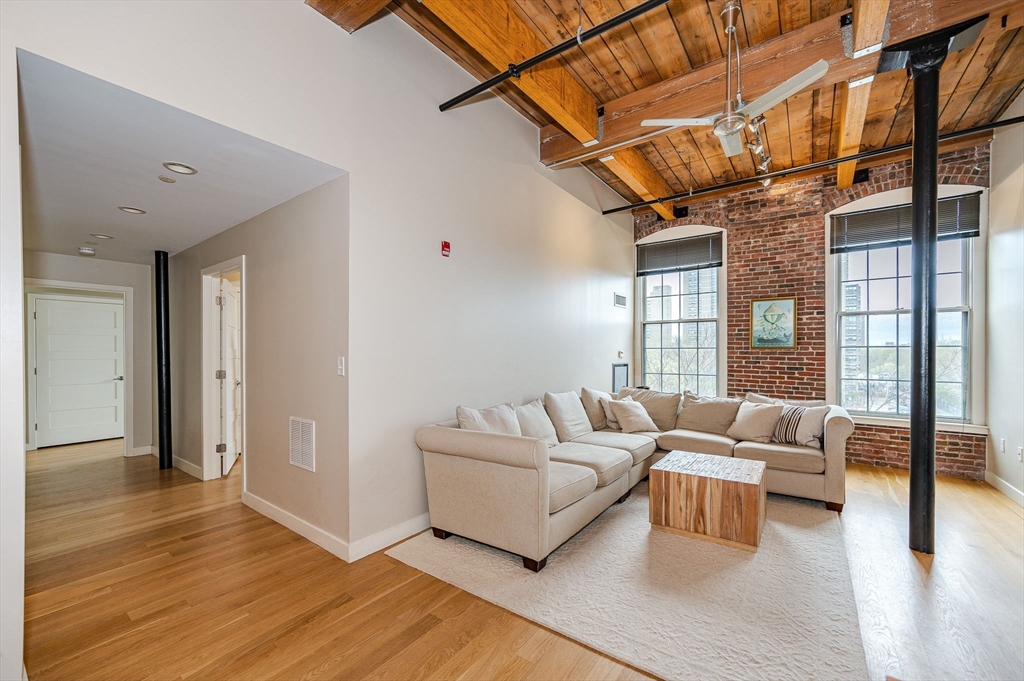 a living room with furniture wooden floor and a large window