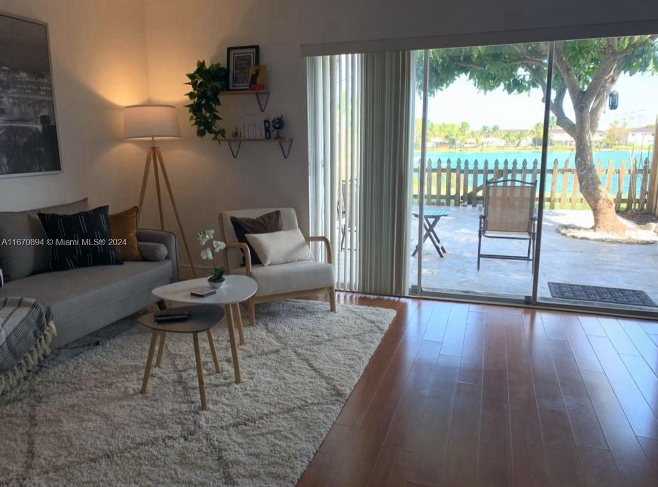 a living room with furniture and a floor to ceiling window