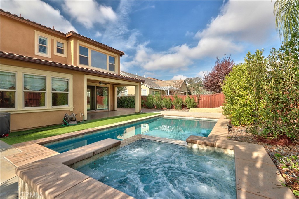 a view of a house with swimming pool and sitting area