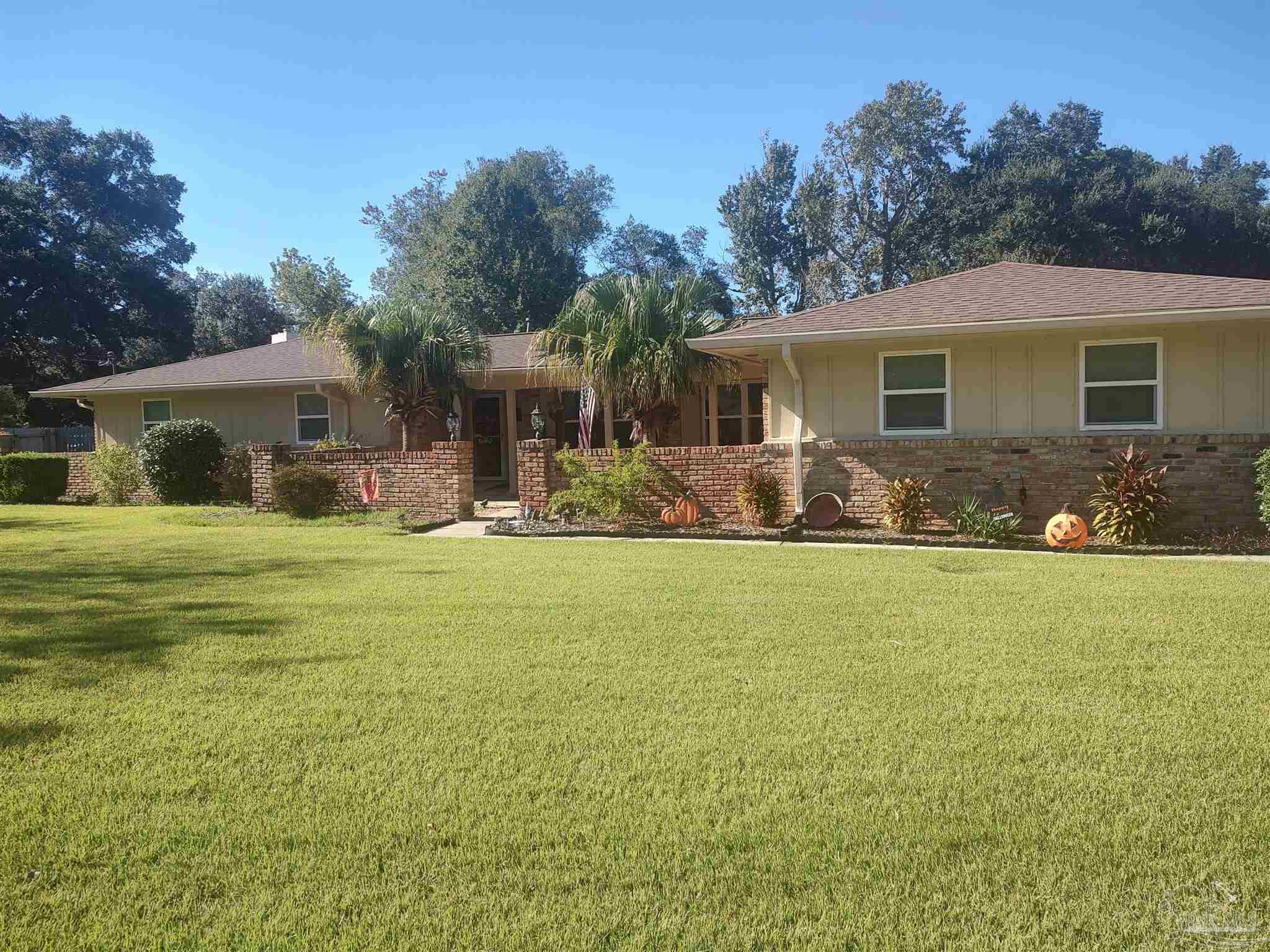 a front view of house with yard seating and green space