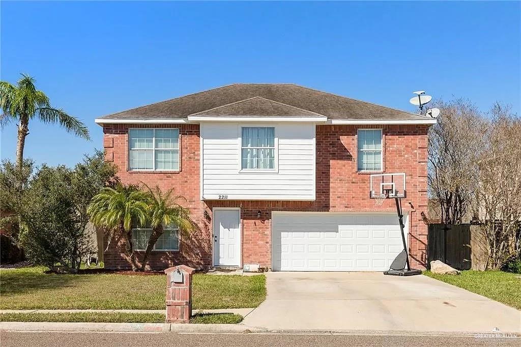 View of front of home with a front lawn and a garage