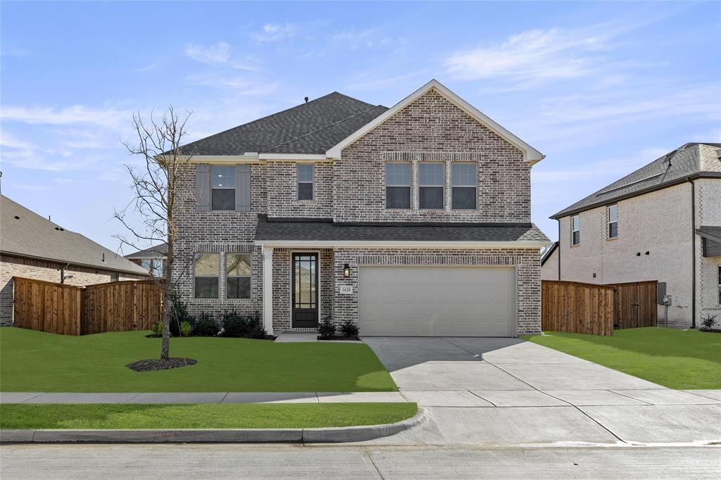 a front view of a house with a garden and yard