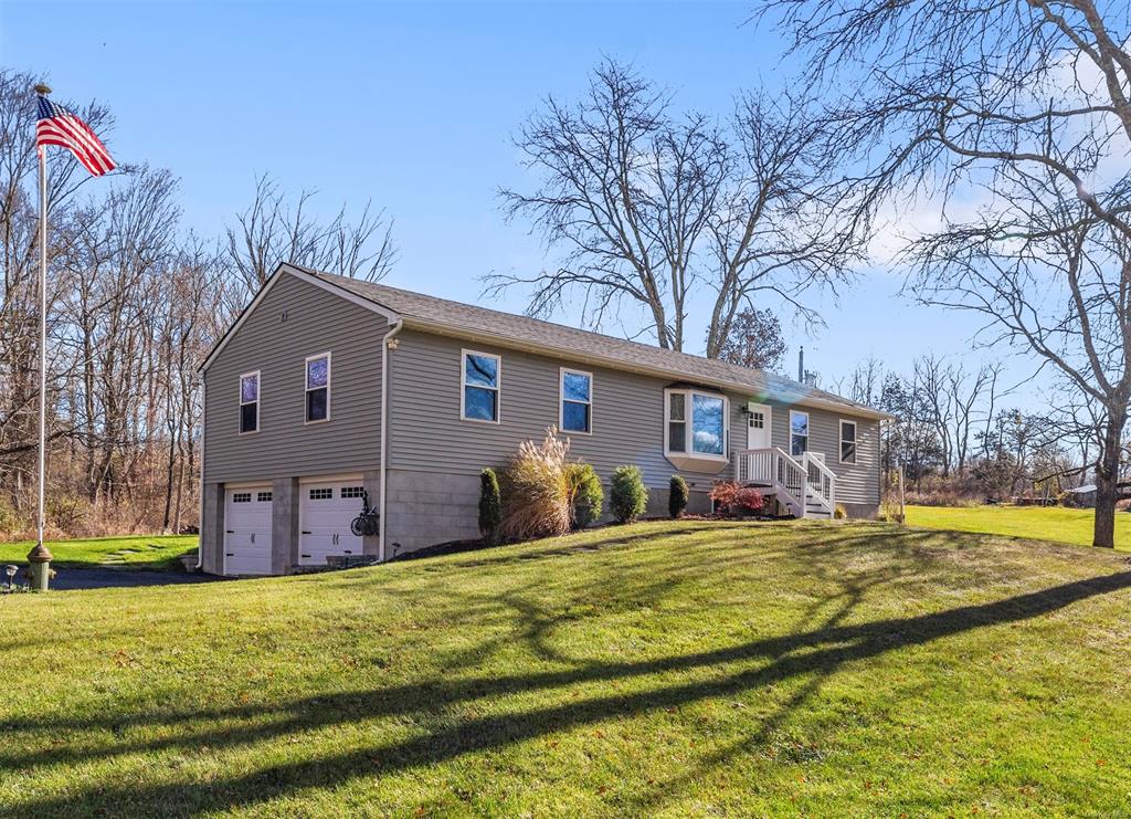 View of front of house with a garage and a front yard