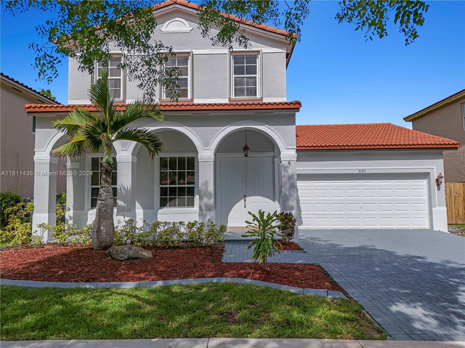 a front view of a house with a garden