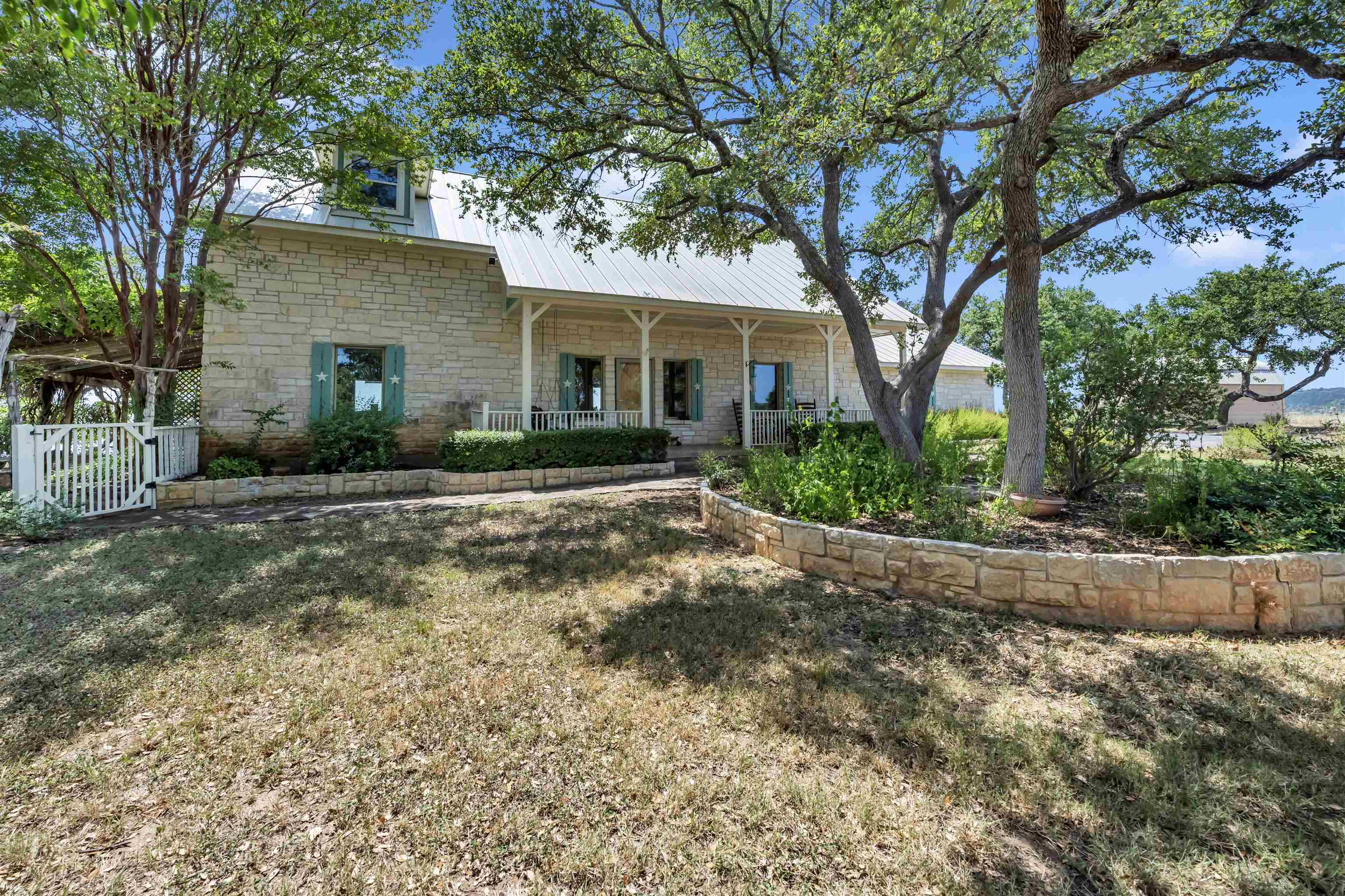 a front view of a house with garden and trees