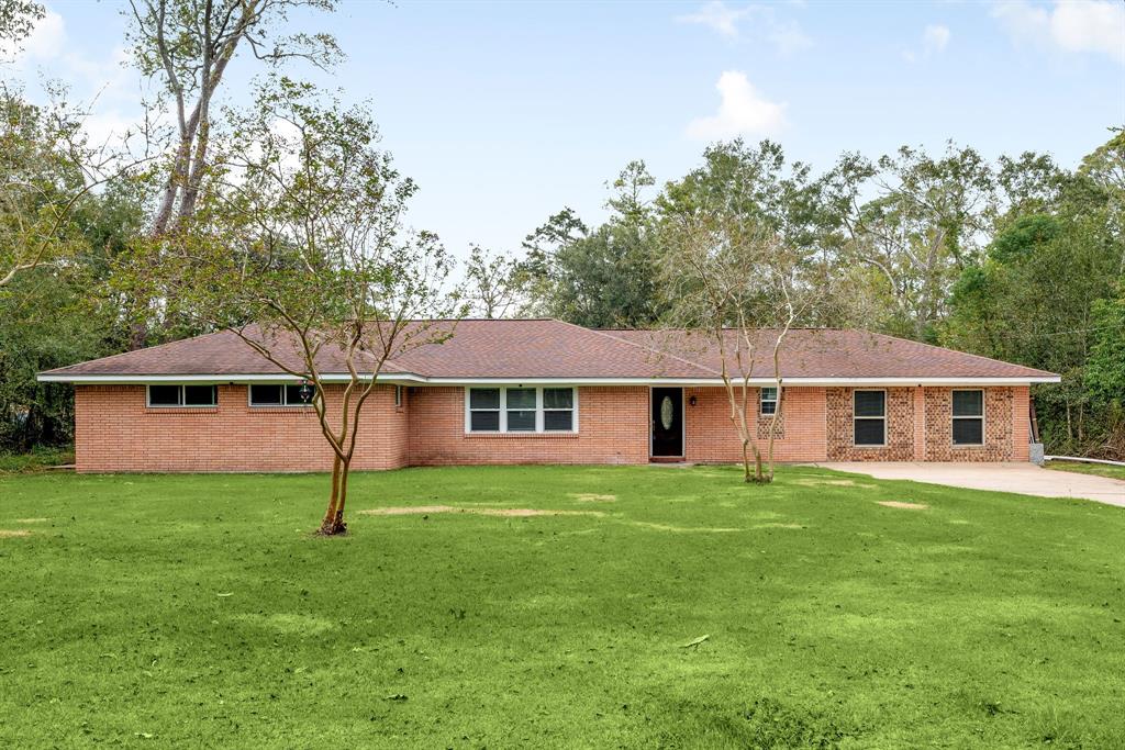 a white house with a big yard and large trees