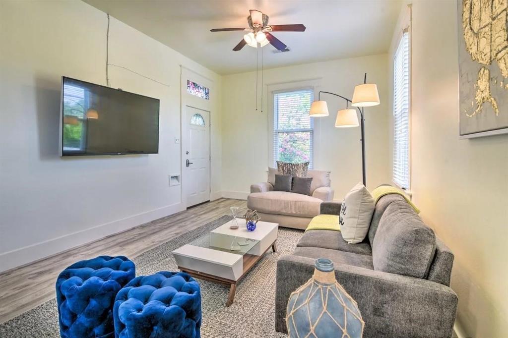 a living room with furniture a rug and a flat screen tv