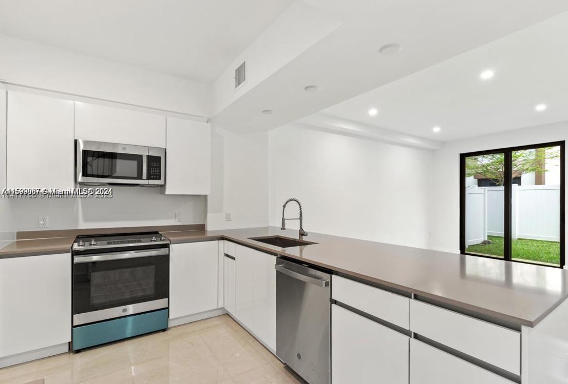 a kitchen with a sink stove and microwave