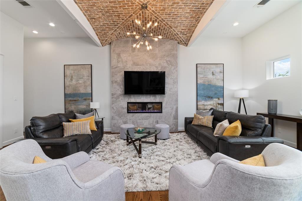 Spacious living room features a mock fireplace and access to the balcony.