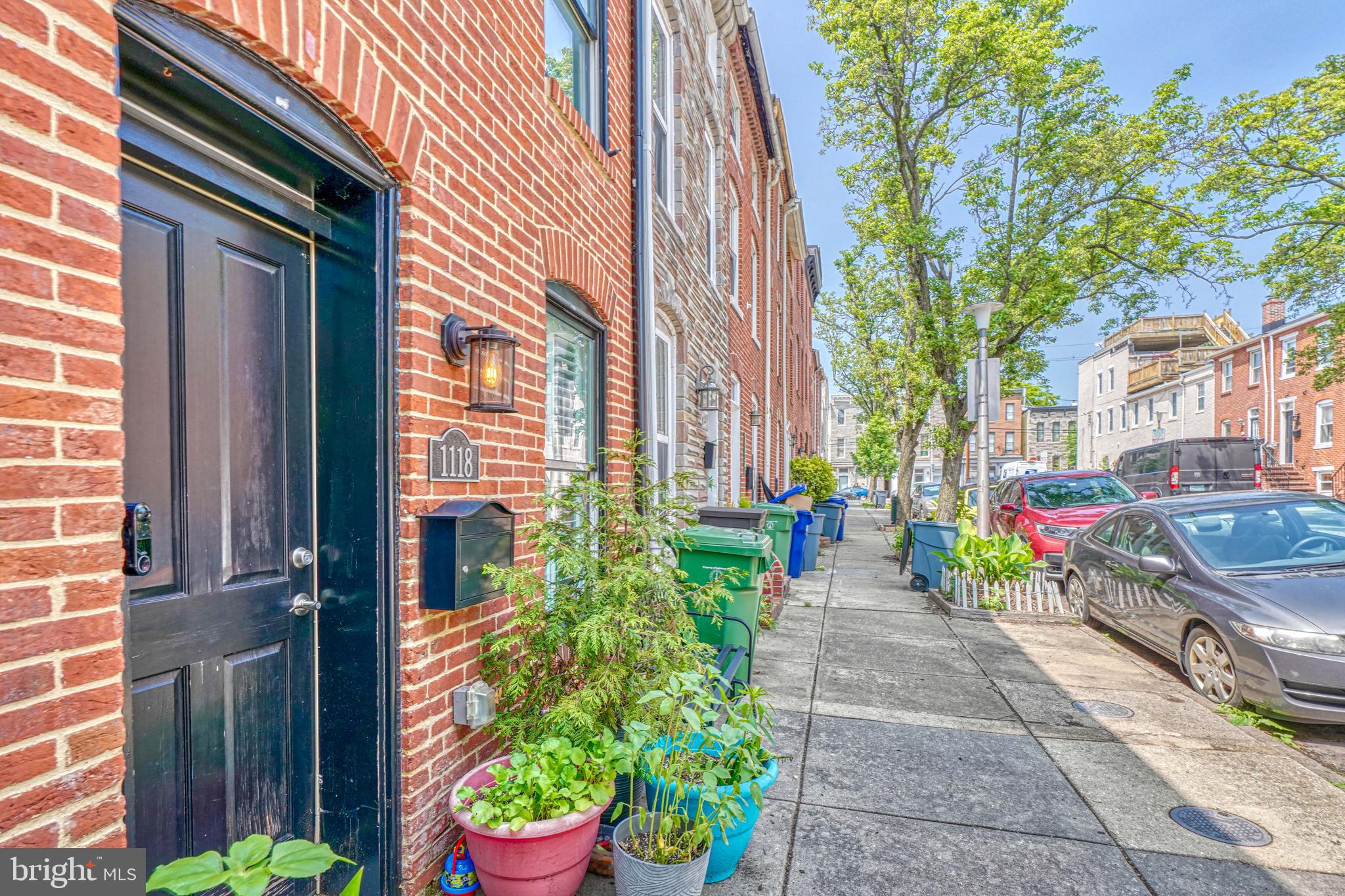 a front view of a house with a yard and potted plants