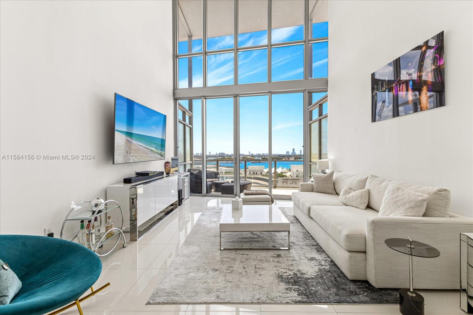 a living room with furniture a rug and a floor to ceiling window