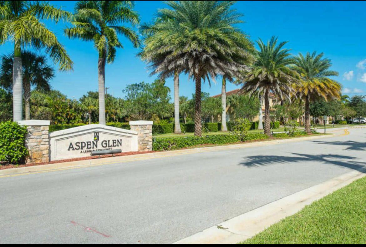 a sign board with a yard and palm trees