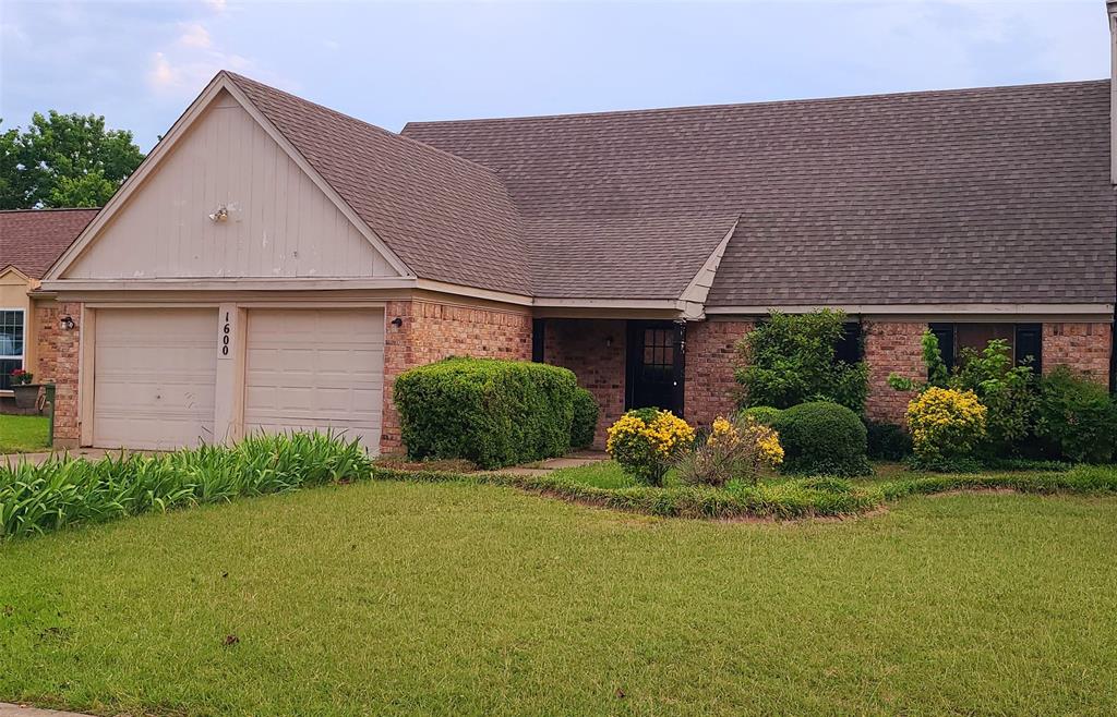 a front view of a house with a garden and plants