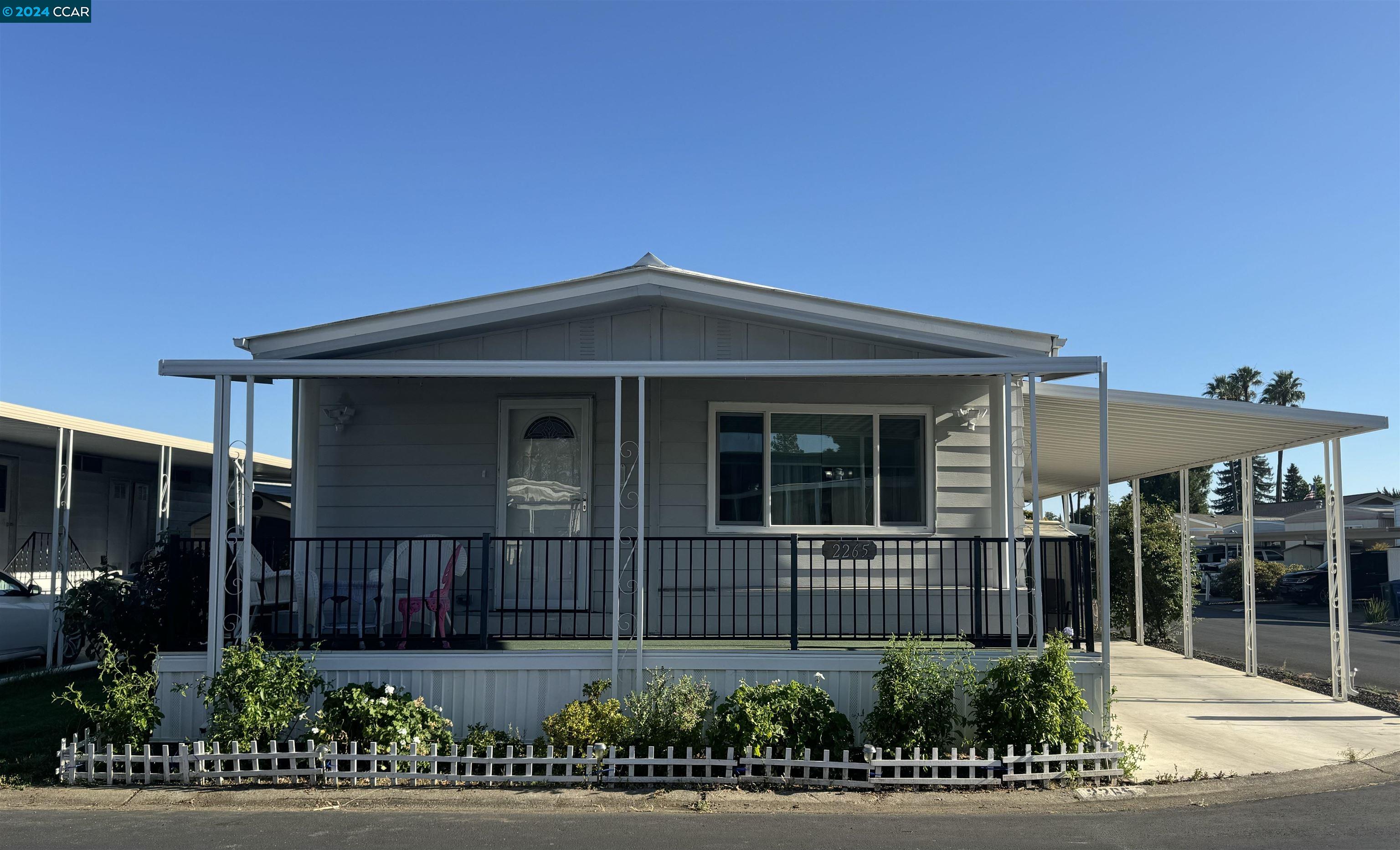 a view of a house with a small yard and potted plants