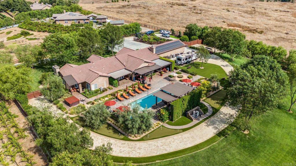 an aerial view of residential houses with outdoor space and trees